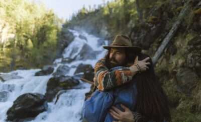 Couple hugging next to a body of water