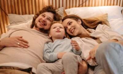 Parents with toddler in the middle of the bed with them